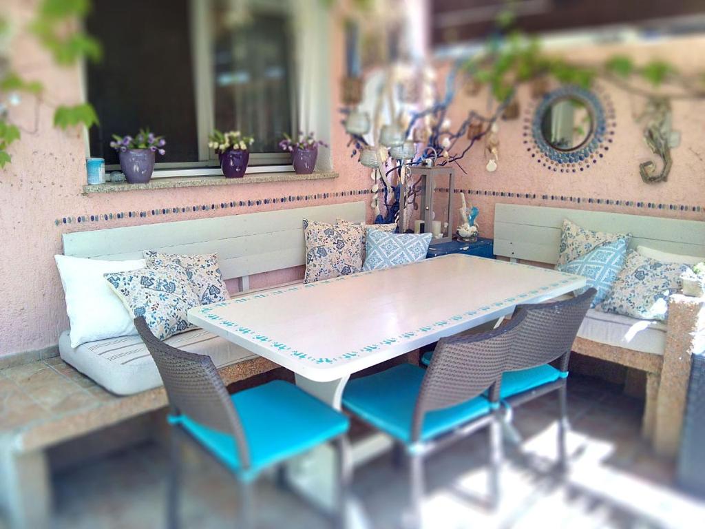 un patio con tavolo, sedie e cuscini di B&B Olbia a Olbia