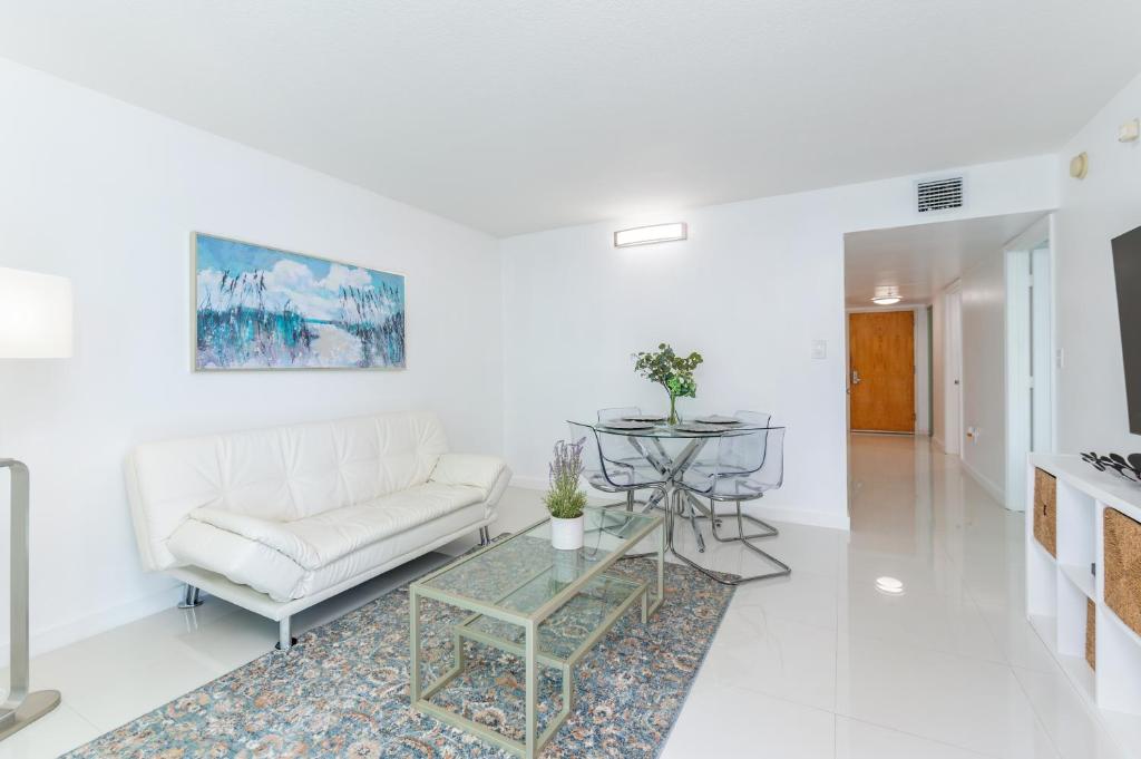 un soggiorno con un divano bianco e un tavolo di Bright and Cozy 2BR at Brickell, Free Parking a Miami