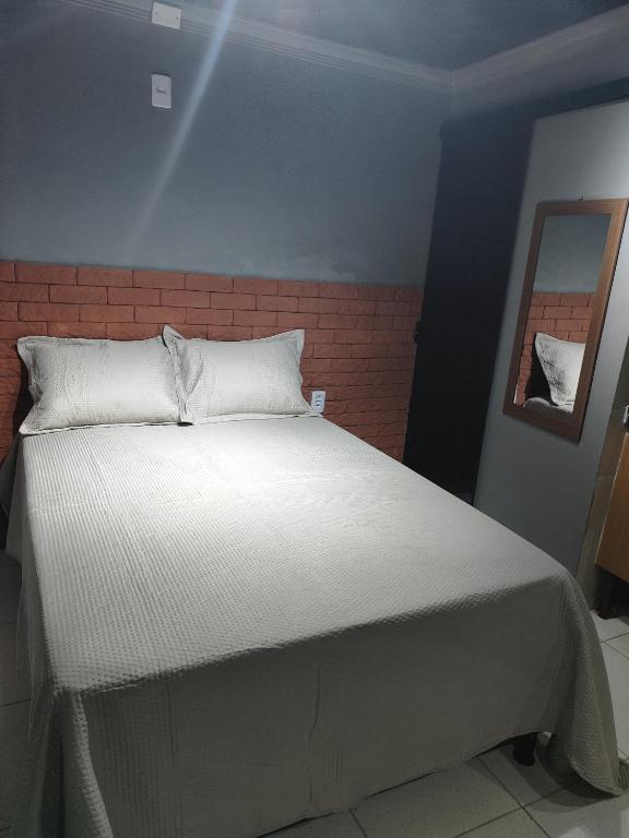 a bedroom with a large bed with white sheets at Loftjesus in Campina Grande