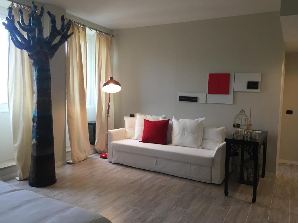 a living room with a white couch and a tree at So&Leo Guest House in Genova