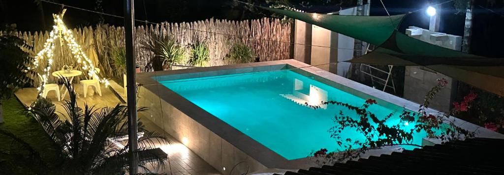 ein Schwimmbad in einem Garten in der Nacht in der Unterkunft Costa azul para 15 personas in Sonsonate