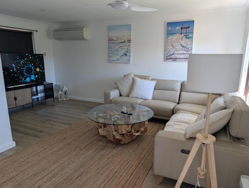 a living room with a couch and a coffee table at Madora Bay Beach House in Singleton