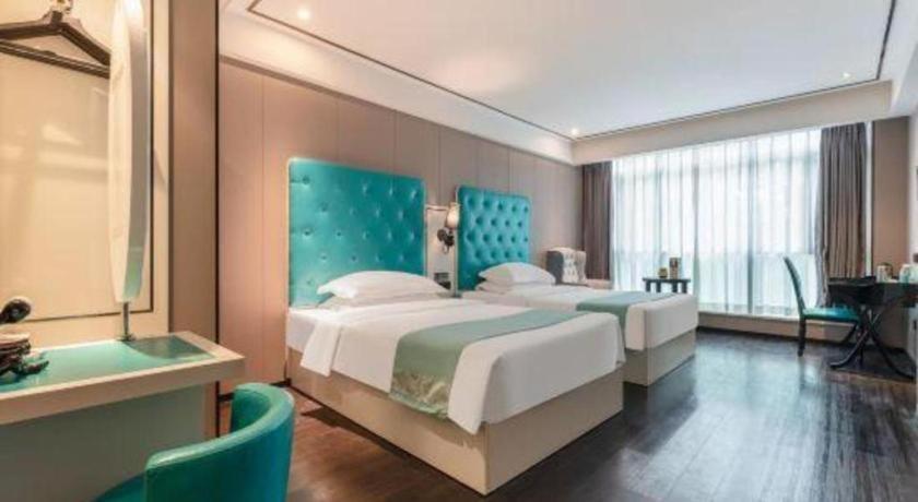 une chambre d'hôtel avec deux lits et une baignoire dans l'établissement Xana Hotelle Huizhou Big World, à Huizhou