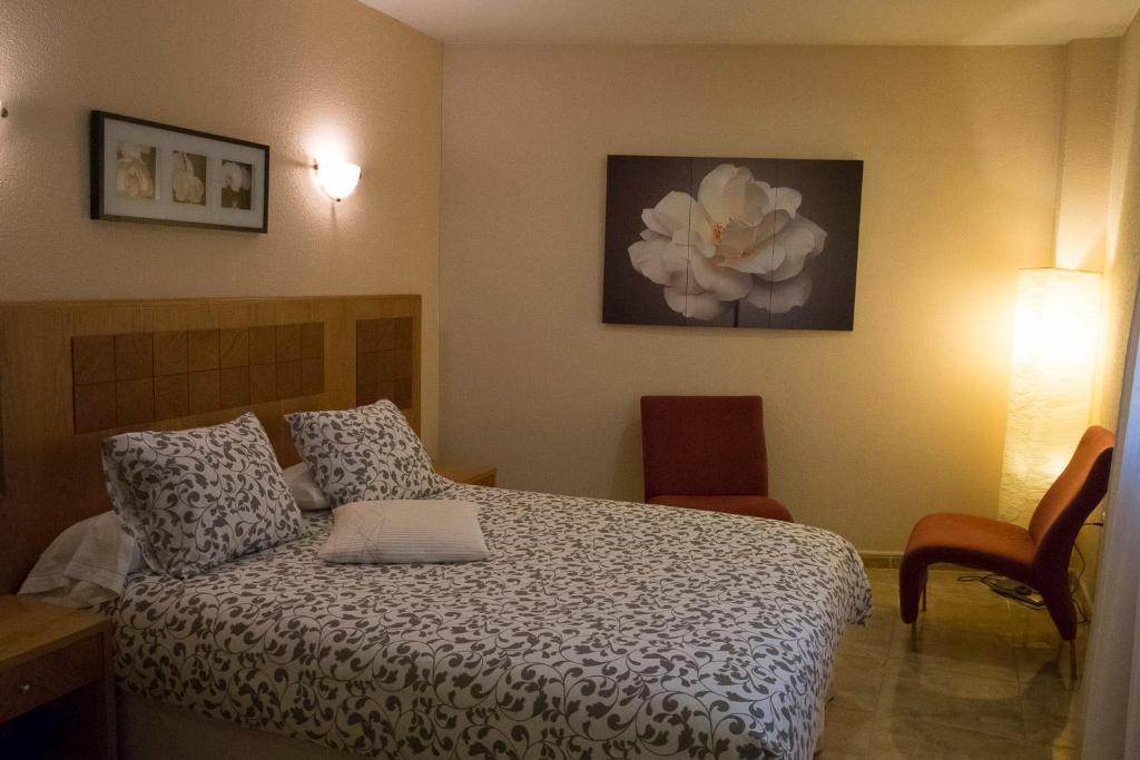 a bedroom with a bed with a flower painting on the wall at Hostal Azul in El Molar