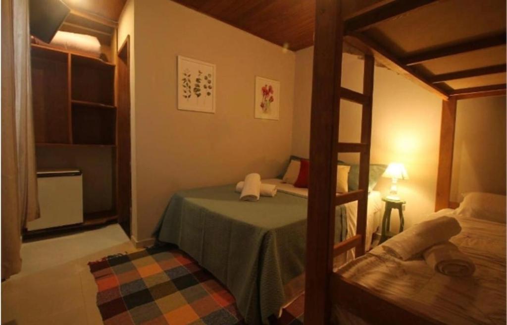 a bedroom with a bunk bed and a ladder at Canoa Ilha Grande in Abraão