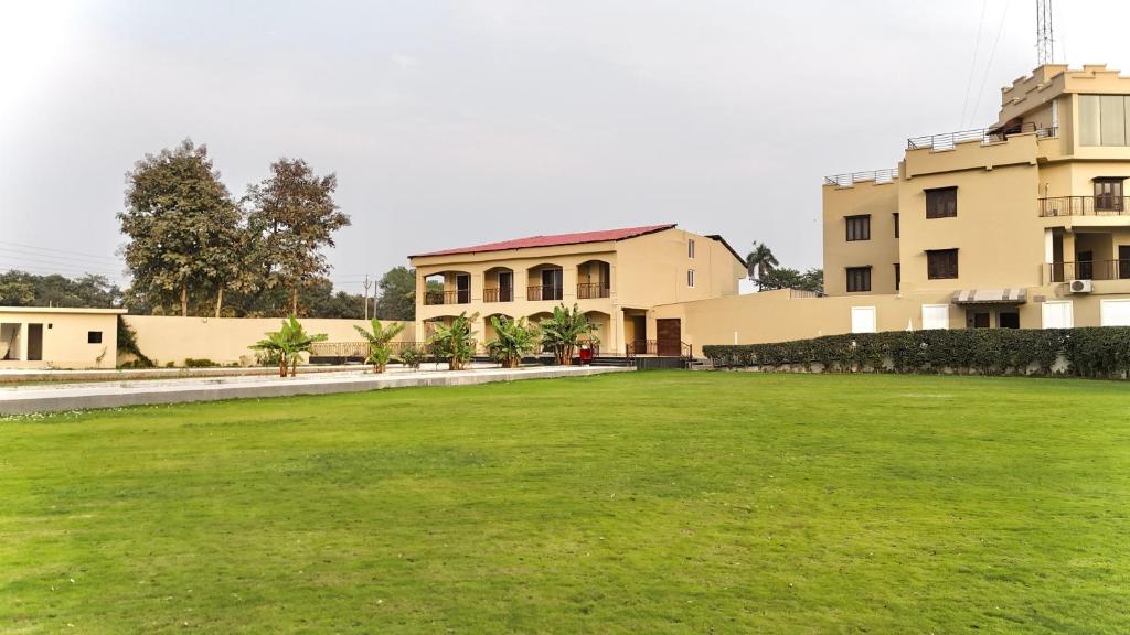 a large grassy field in front of a building at Jashn Wellness Resort Lucknow in Lucknow