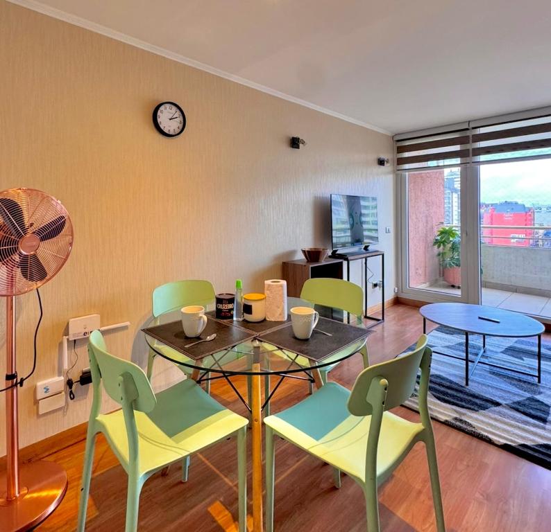 Un comedor con una mesa y sillas y un reloj. en Centro Temuco 4, en Temuco