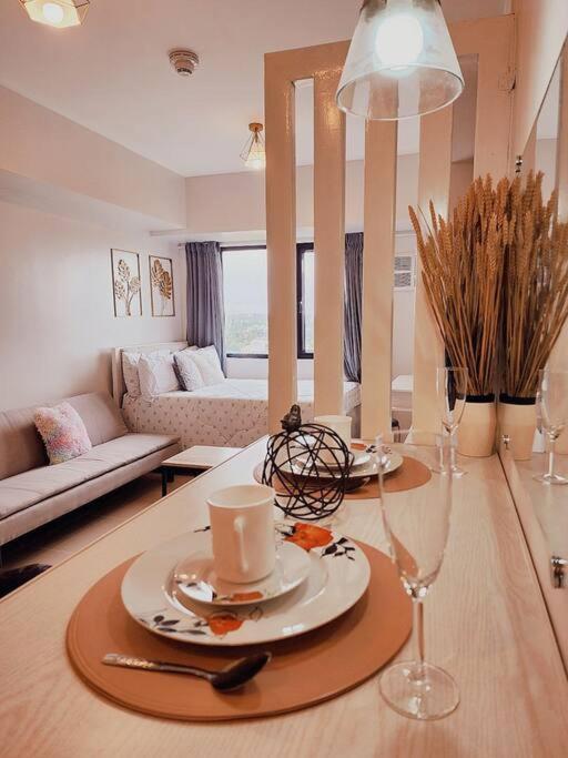 a living room with a table with a plate and wine glasses at Preum Properties Tagaytay in Tagaytay