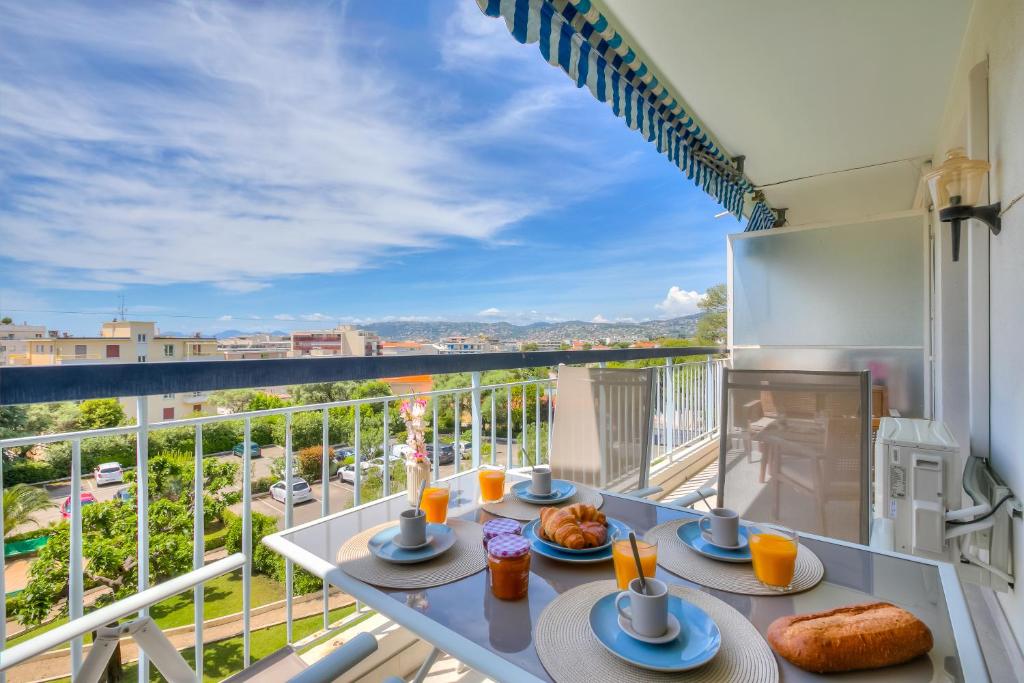 - un balcon avec une table et de la nourriture dans l'établissement Lovely Apartment - 5min From Beach - Happy Rentals, à Juan-les-Pins