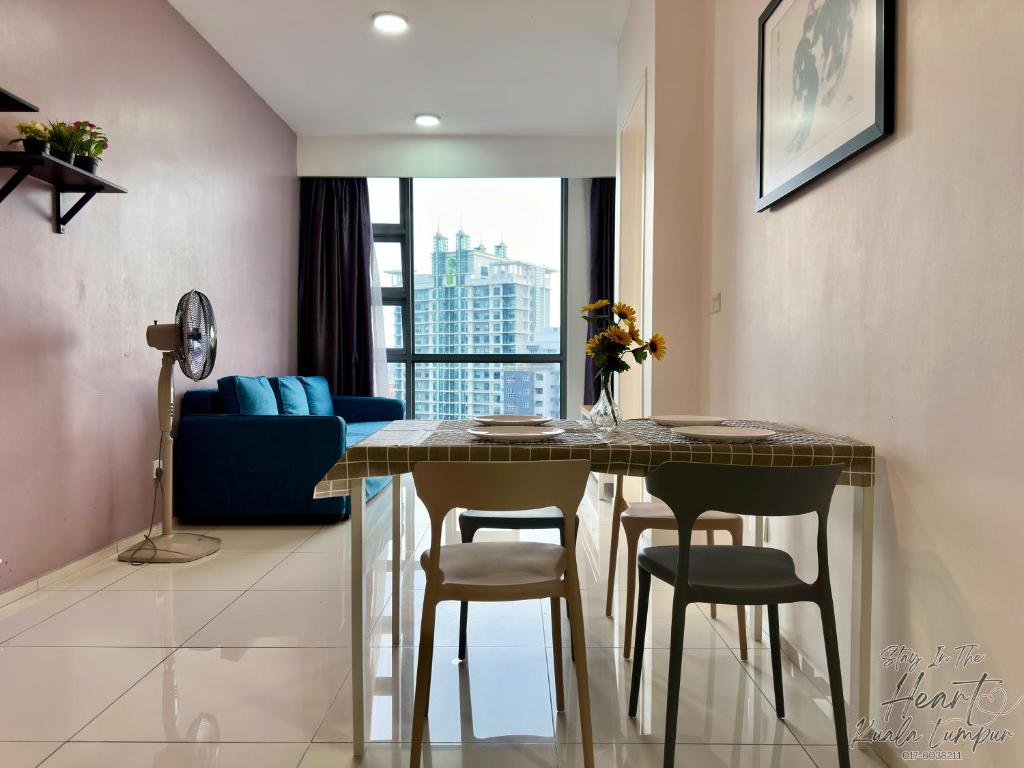 a living room with a dining room table and chairs at Cozy Minimalist Condo In The Heart of Kuala Lumpur City 1BR in Kuala Lumpur