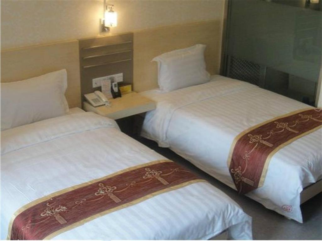 Postel nebo postele na pokoji v ubytování Guang Dong Hotel
