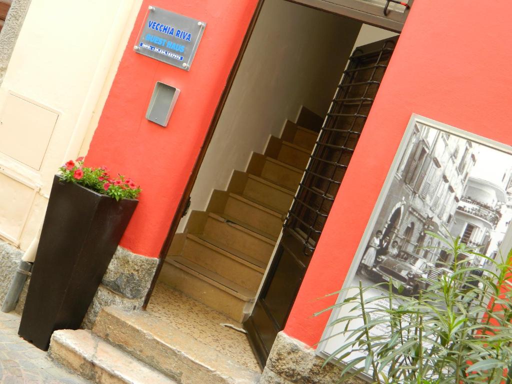 un edificio rosso con scale e un cartello sopra di Vecchia Riva a Riva del Garda