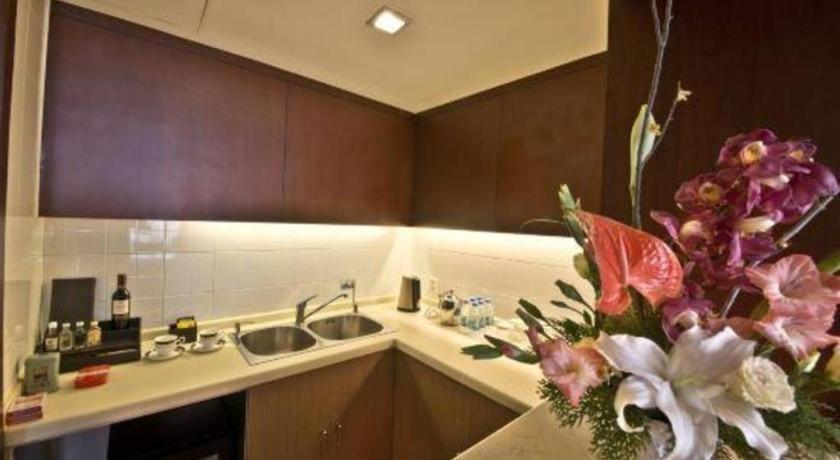 a kitchen with a sink and a vase of flowers at Argyle International Airport Hotel Shanghai in Shanghai