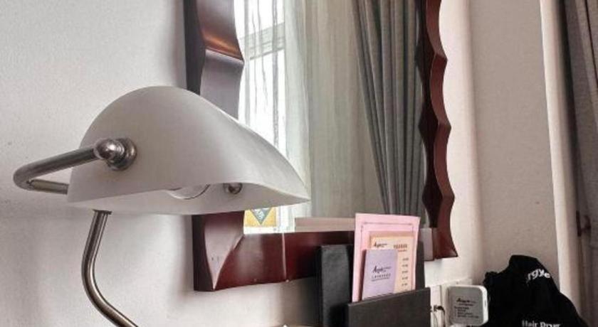 a white lamp in a room with a mirror at Argyle International Airport Hotel Shanghai in Shanghai
