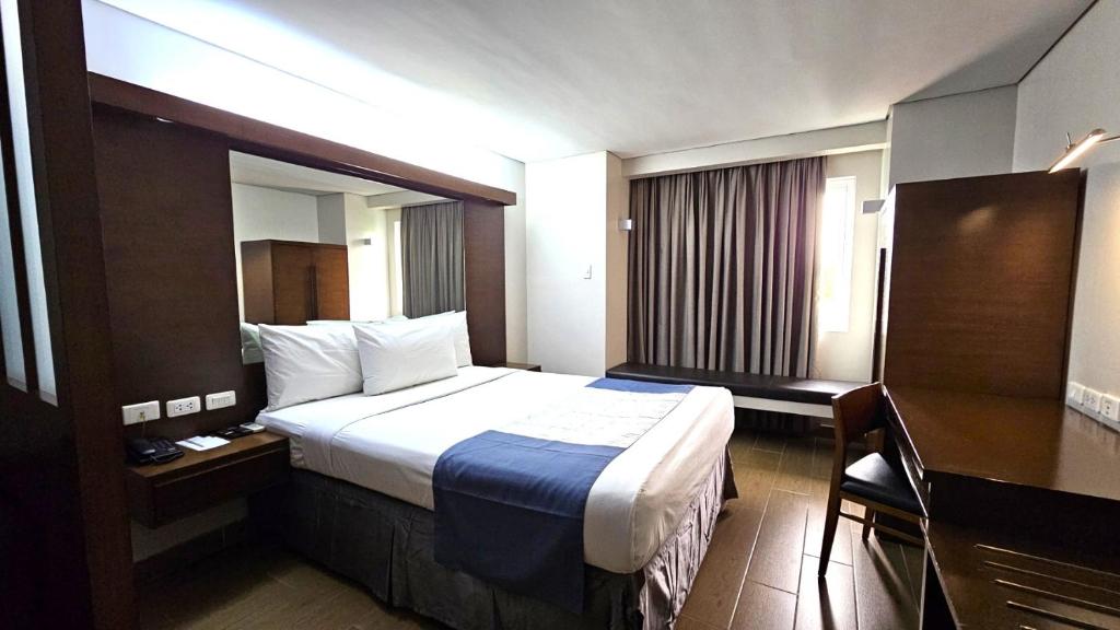Postel nebo postele na pokoji v ubytování Microtel by Wyndham Acropolis