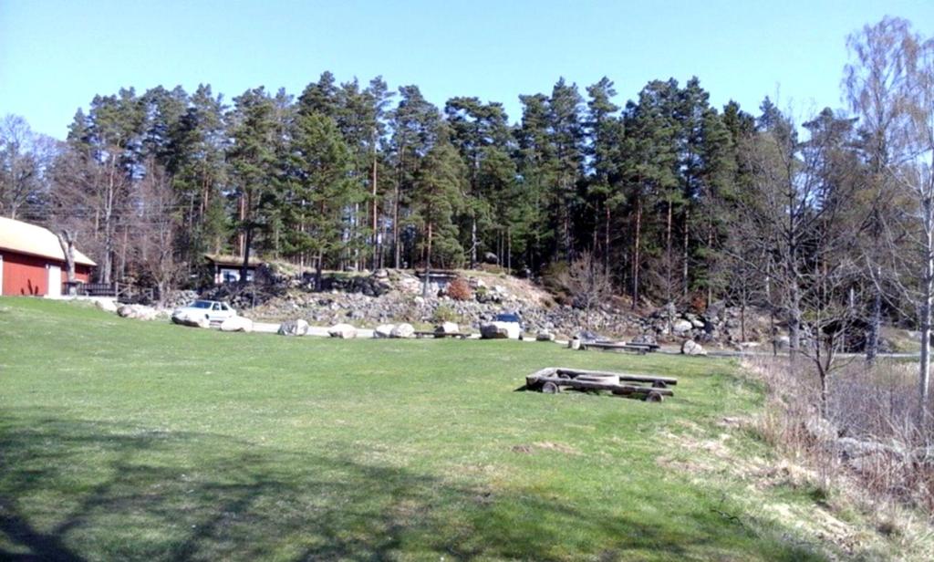 a park with a bench in a field with trees at Hjärtasjöstugor in Lönsboda