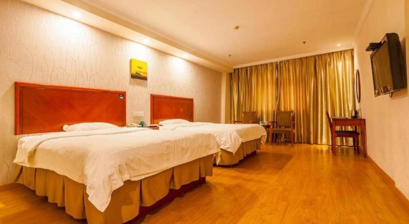 a hotel room with two beds and a flat screen tv at GreenTree Inn Kunshan Shimao Plaza Business Hotel in Penglang