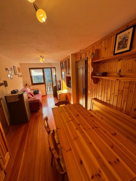 a living room with a wooden table in a room at Casa Gatto in Auronzo di Cadore