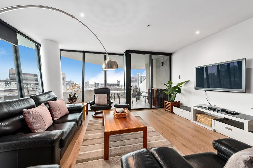 a living room with a couch and a table at Docklands Private Collection - NEWQUAY in Melbourne