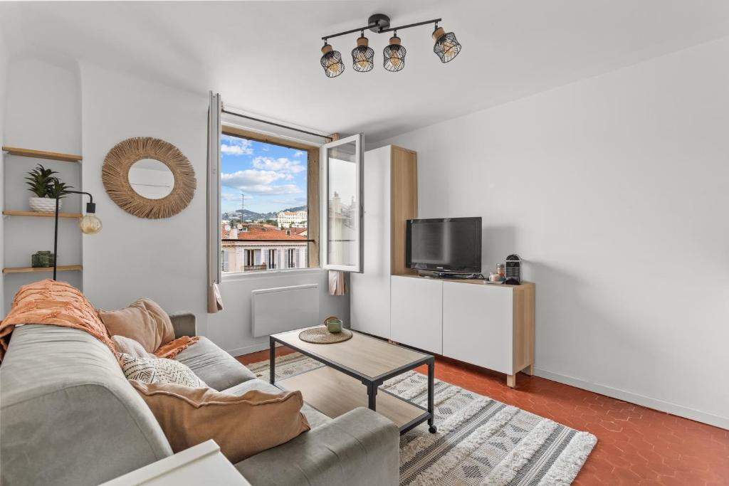 un salon avec un canapé et une télévision dans l'établissement Cosy Studio, Cannes centre, à Cannes