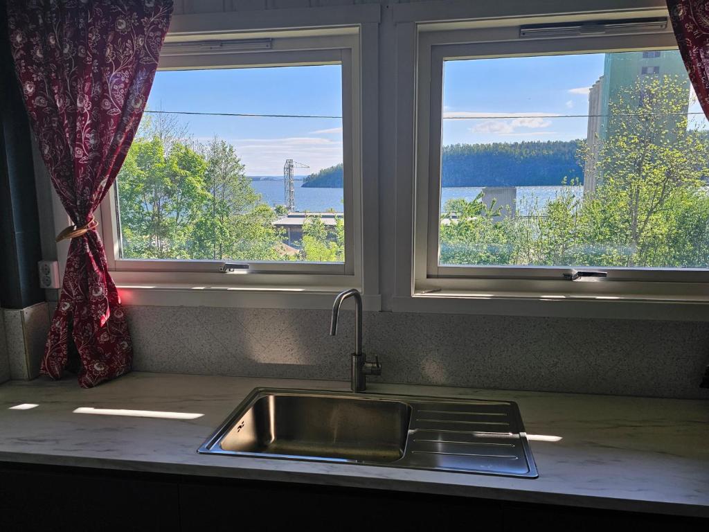 encimera de cocina con fregadero y 2 ventanas en Leilighet i Holmestrand, en Holmestrand
