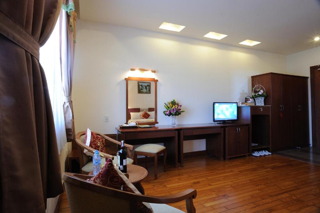 a living room with a desk and a television at Hoang Yen 2 Hotel in Thu Dau Mot