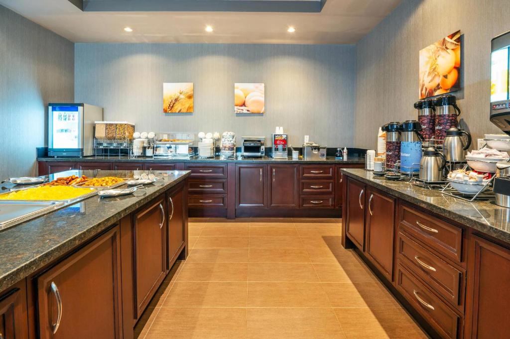 a large kitchen with wooden cabinets and counter tops at Comfort Inn & Conference Centre Toronto Airport in Toronto