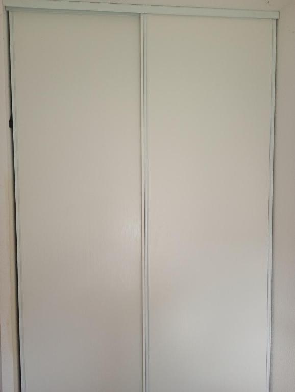 une paire de portes de placard blanches dans une pièce dans l'établissement Chambre 1 personne, à La Celle-sous-Gouzon
