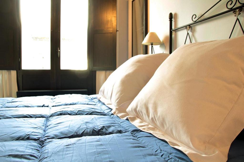 a bed with two pillows on it in a bedroom at Apartamento Senderos de Hervas in Hervás