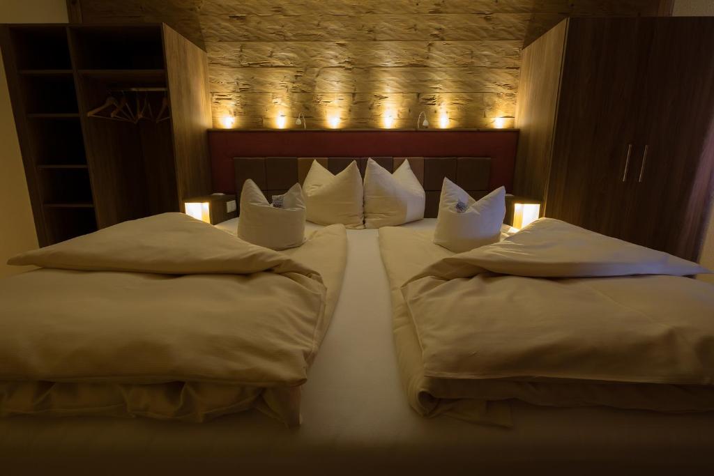 a bedroom with two beds with pillows and lights at Landgasthof Zum Lang in Gottsdorf