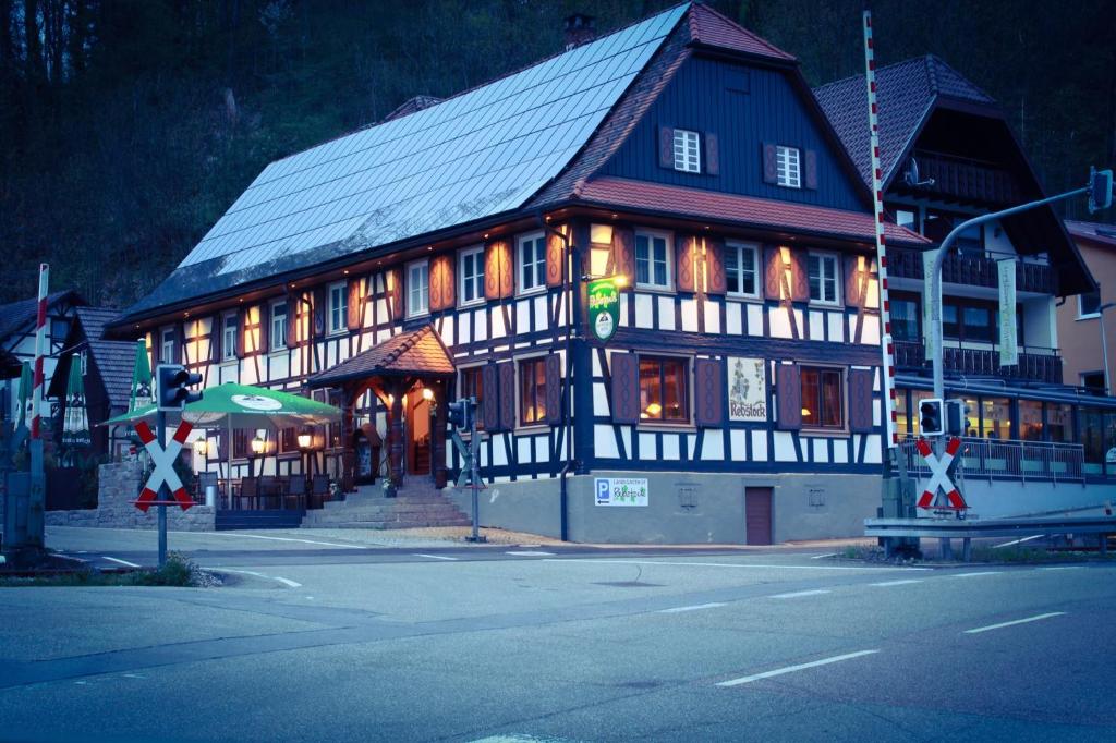 a large black and white building on the corner of a street at Landgasthof Rebstock in Ottenhöfen