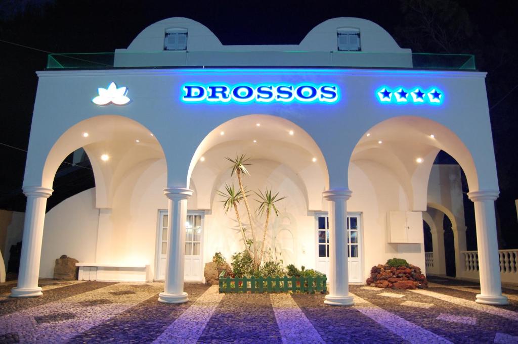 a building with a clock on the front of it at Drossos Hotel in Perissa