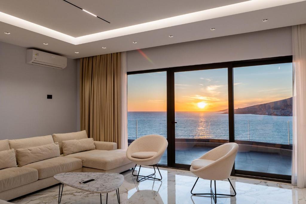 a living room with a couch and a view of the ocean at Day Lux Superior Apartments in Sarandë