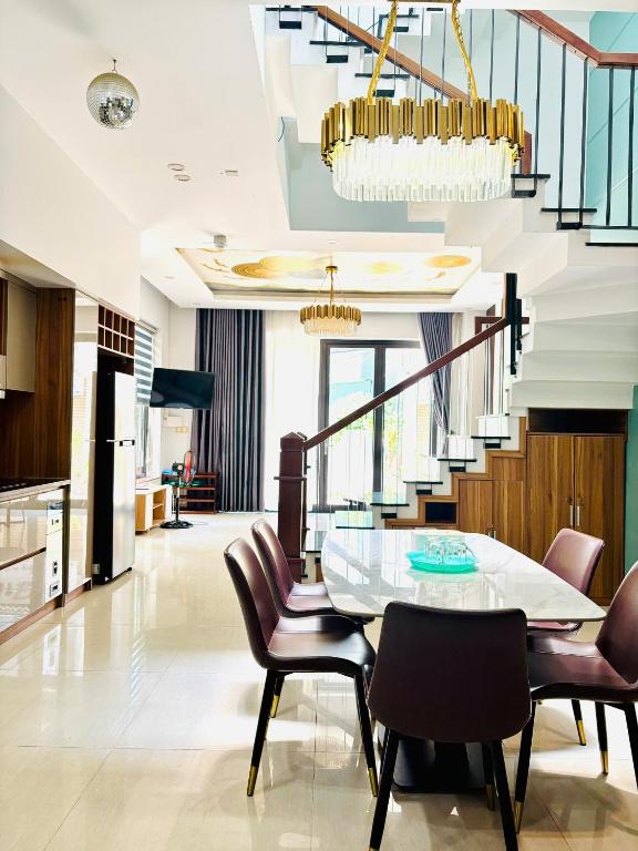 a dining room with a table and chairs and a staircase at Sunrise Homestay in Danang