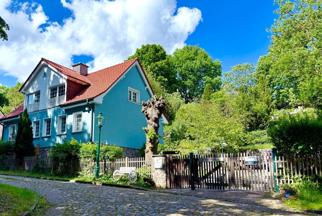 a blue house with a fence on a street at Landhaus am See Flecken Zechlin in Rheinsberg