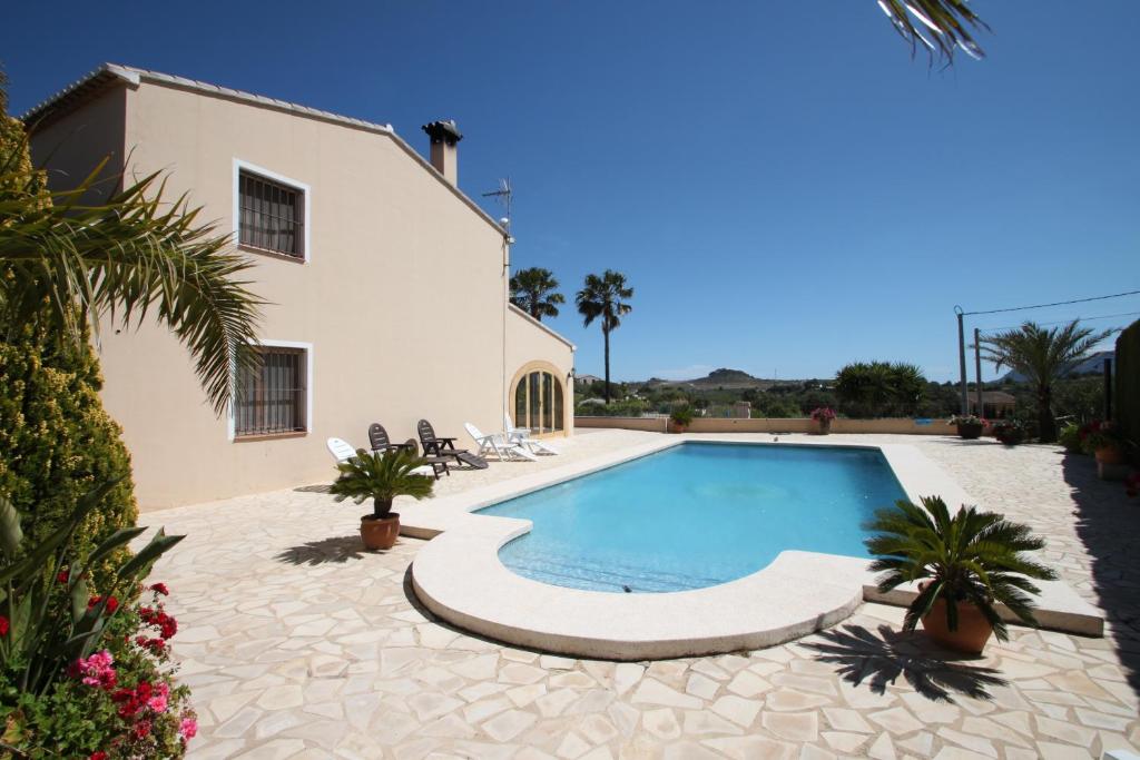 a swimming pool in front of a house at Finca Cantares - holiday home with private swimming pool in Benissa in Benissa