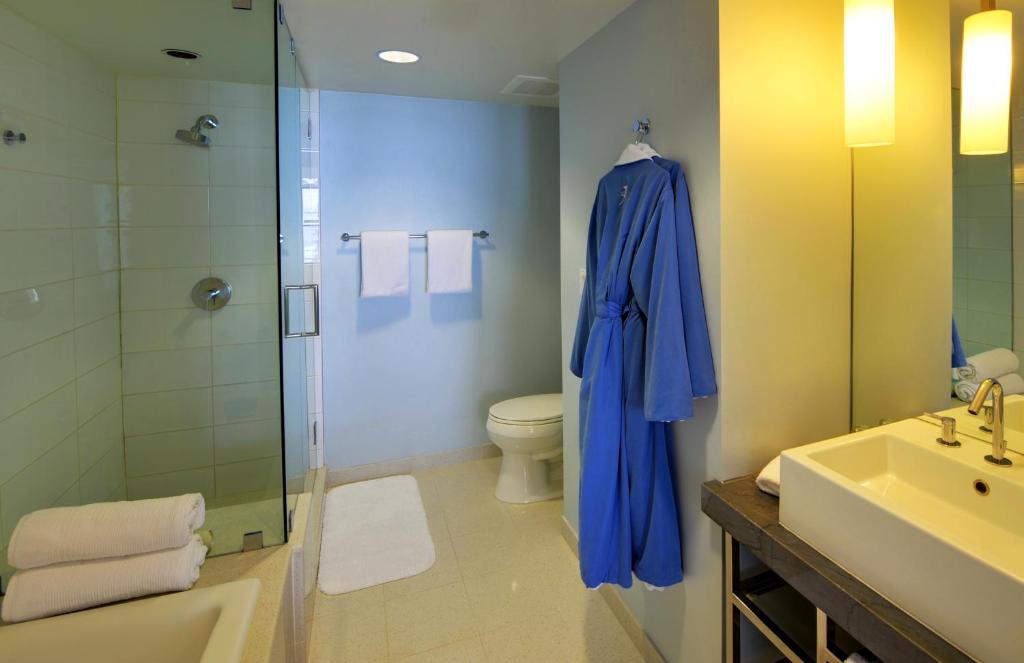 a bathroom with a shower and a blue robe at Tower 23 Hotel in San Diego