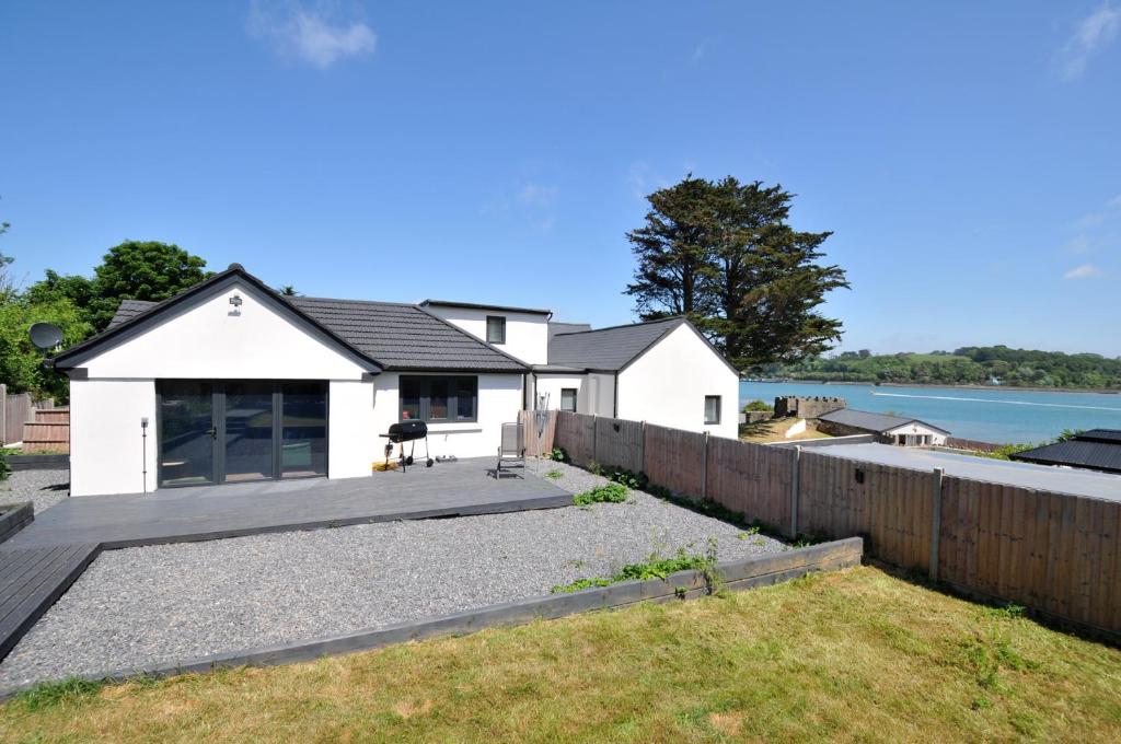 a white house with a fence and a yard at The Mooring in Bideford