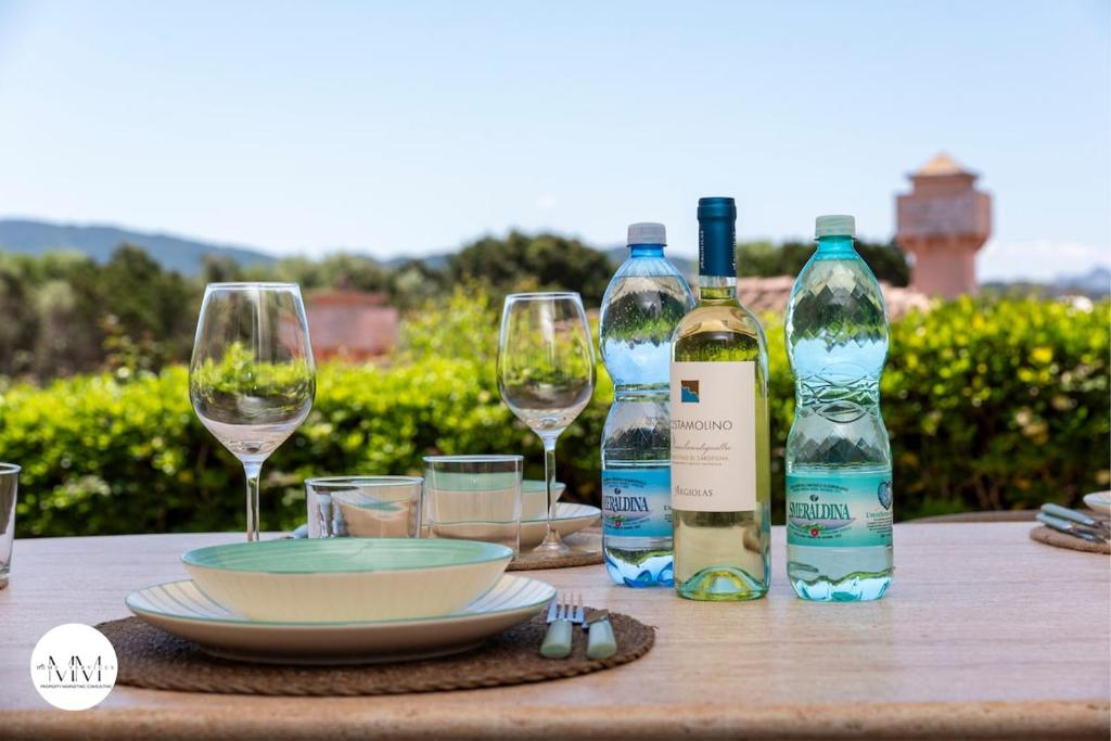 a table with two bottles of wine and glasses at Porto Cervo Villa Sara in Porto Cervo