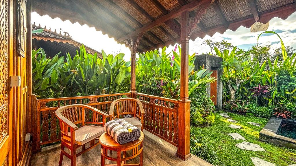 a porch with two chairs and a garden at Padiku Villa Semana Private Pool in Badung