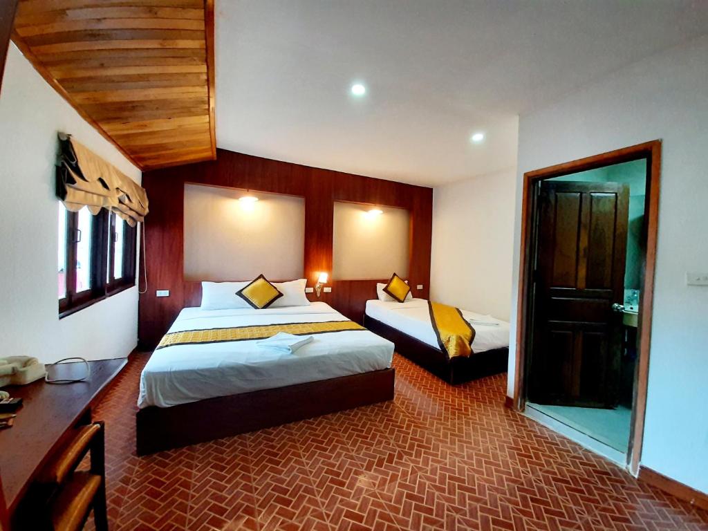 een hotelkamer met twee bedden en een spiegel bij Lacasa Mountain View Hotel in Vang Vieng