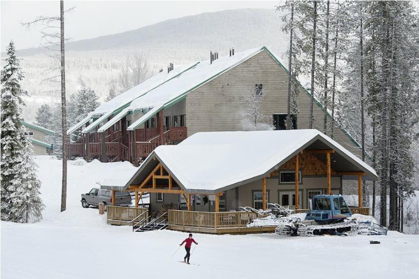 a person skiing in the snow in front of a cabin at Innwest Kirkwood Inn in Kimberley