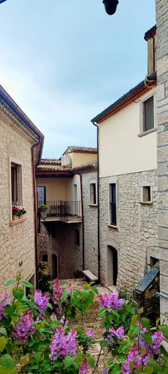 a group of buildings with flowers in a yard at LA ROCCIA DI VICIDOMINI - Affittacamere in San Marco dei Cavoti
