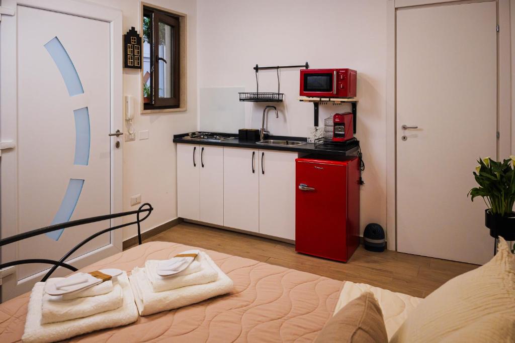 a small kitchen with a red cabinet and a microwave at Il Giardino di Sole in Bari
