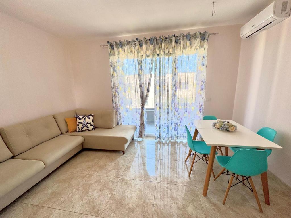 a living room with a couch and a table at Abi Apartment Valamar in Draç