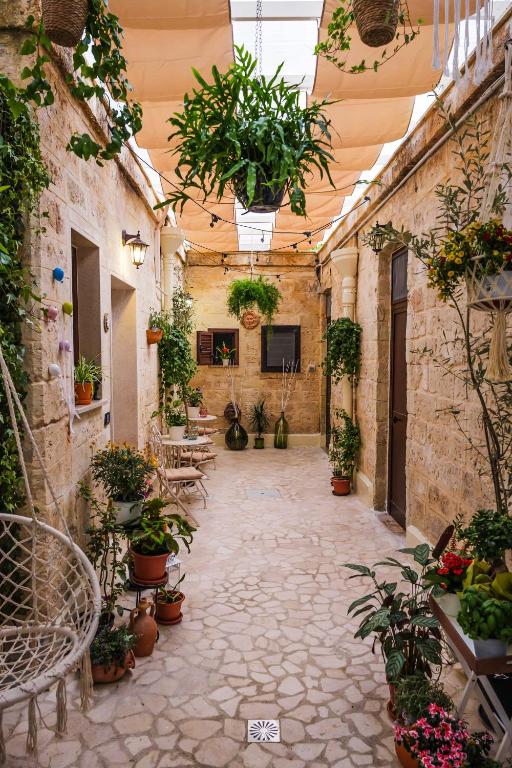 a courtyard with potted plants and tables and chairs at Il Giardino di Sole in Bari