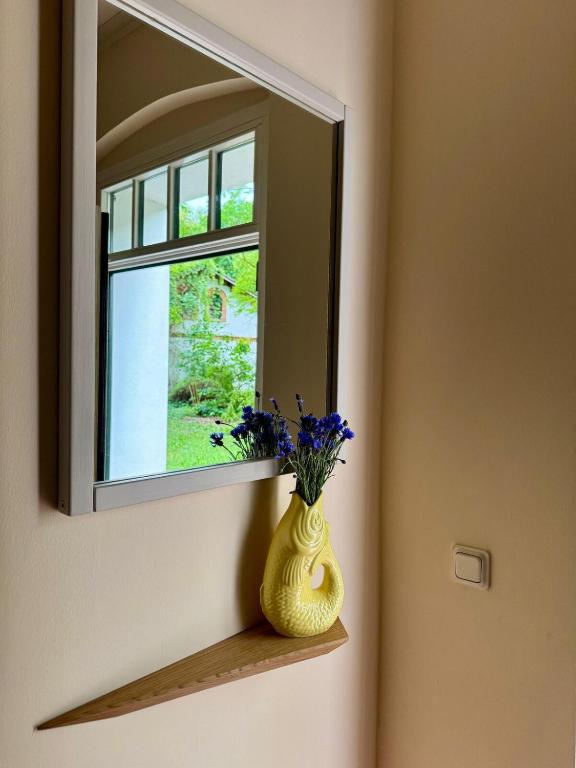 a vase sitting on a shelf in front of a mirror at Ferienapartment Janow in Spantekow