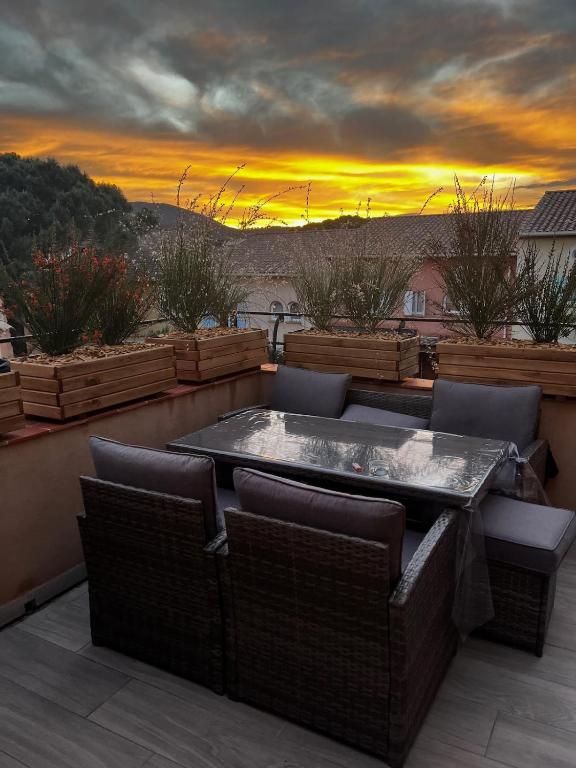 un patio avec un jacuzzi et des chaises avec un coucher de soleil dans l'établissement Villa Lavande, à Sainte-Maxime