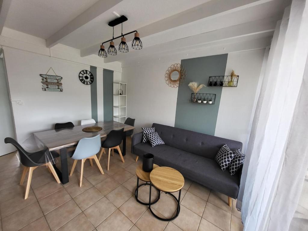 un salon avec un canapé et une table dans l'établissement Maisonnette Mail Rochelongue location samedi au samedi, au Cap d'Agde