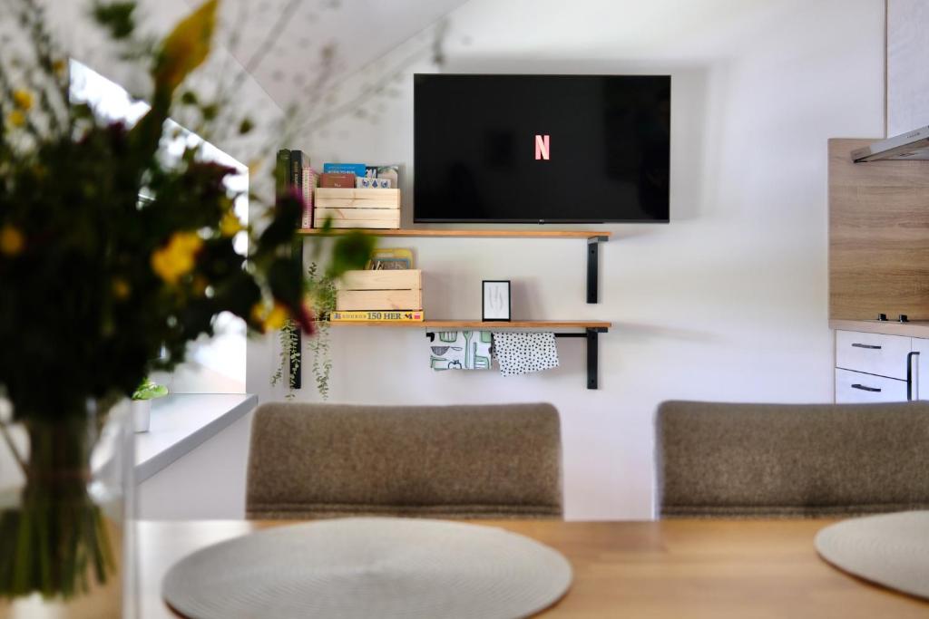 Un comedor con dos sillas y un televisor en una pared. en Klidovka Sumava, en Stachy